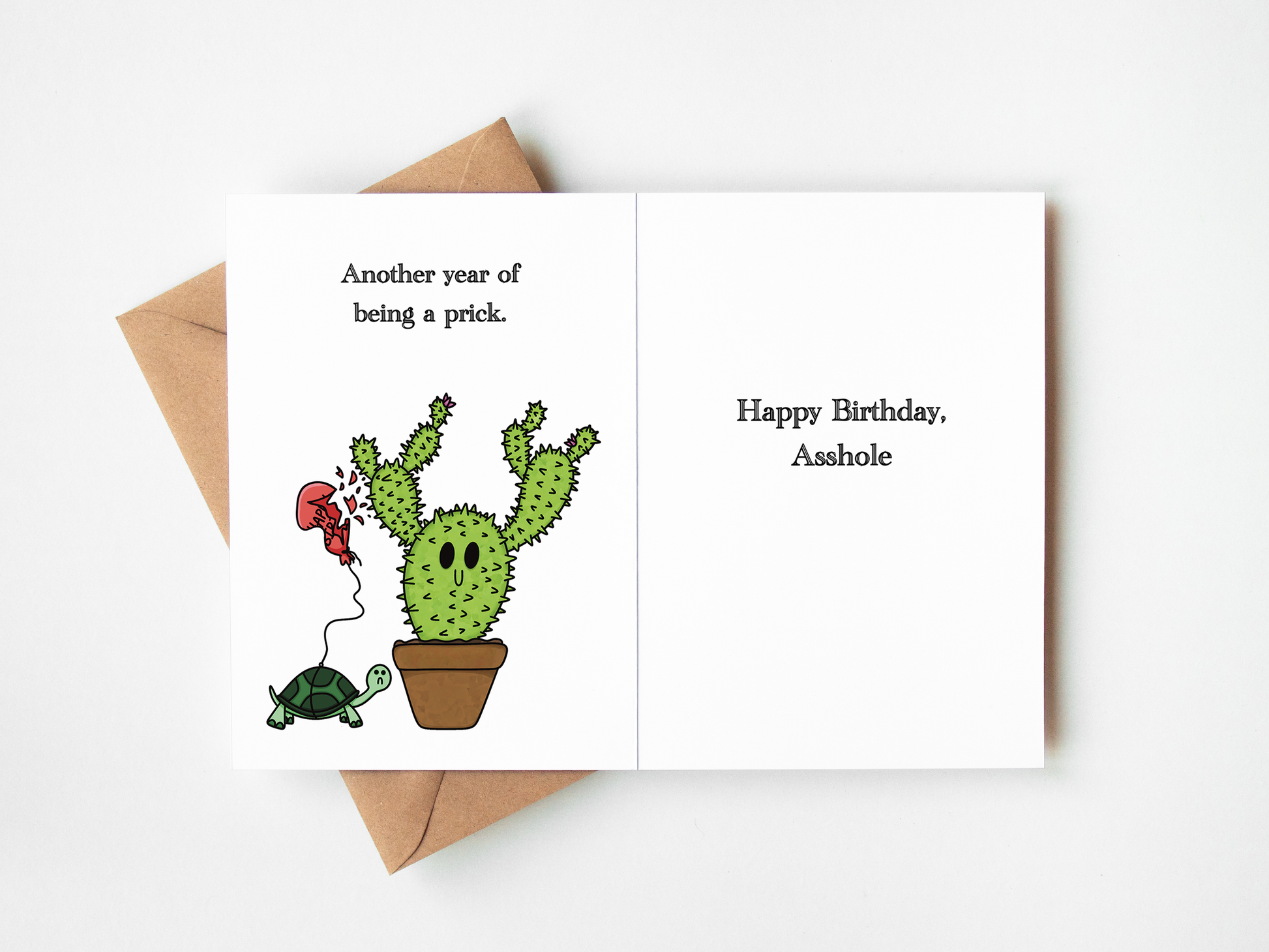 A novelty birthday card shown open on a white background with a brown envelope behind it. The left panel features a cartoon cactus in a pot with a red balloon and a turtle, with the text 'Another year of being a prick.