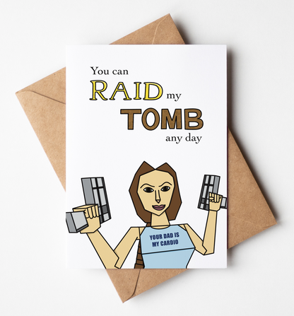 A white greeting card with a humorous graphic and text reading 'You can RAID my TOMB any day' is displayed on top of a brown kraft envelope against a clean white background.