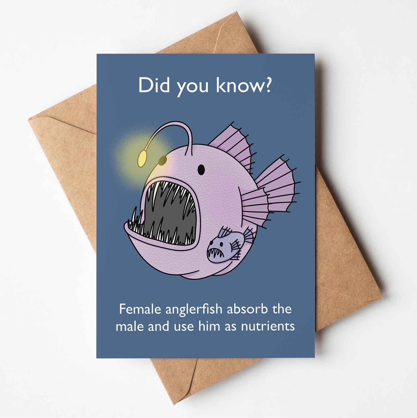 Card with an illustration of an anglerfish and text about female anglerfish absorbing males, on a navy blue background.